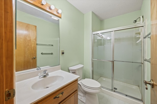 full bath with vanity, a shower stall, toilet, and a textured ceiling