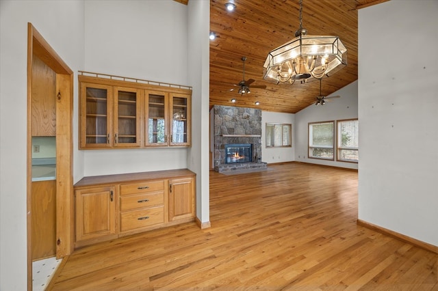 unfurnished living room featuring light wood-style flooring, high vaulted ceiling, a fireplace, and ceiling fan