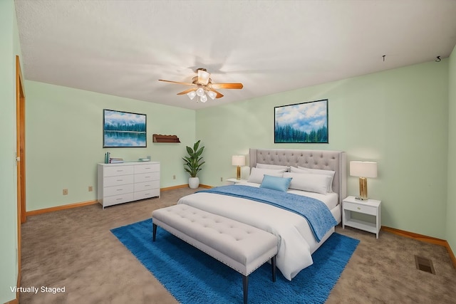 bedroom featuring a ceiling fan, visible vents, baseboards, and carpet floors