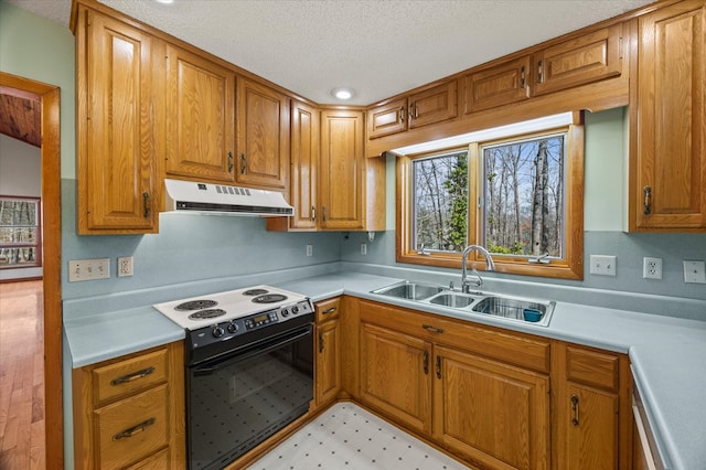 kitchen featuring a sink, extractor fan, light countertops, and electric stove