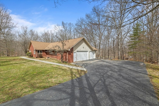 view of front of house with driveway, brick siding, an attached garage, and a front lawn