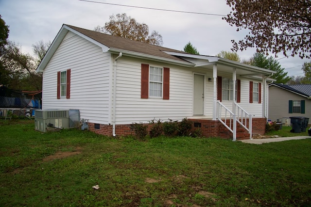 view of front of home with a front yard, crawl space, and central air condition unit