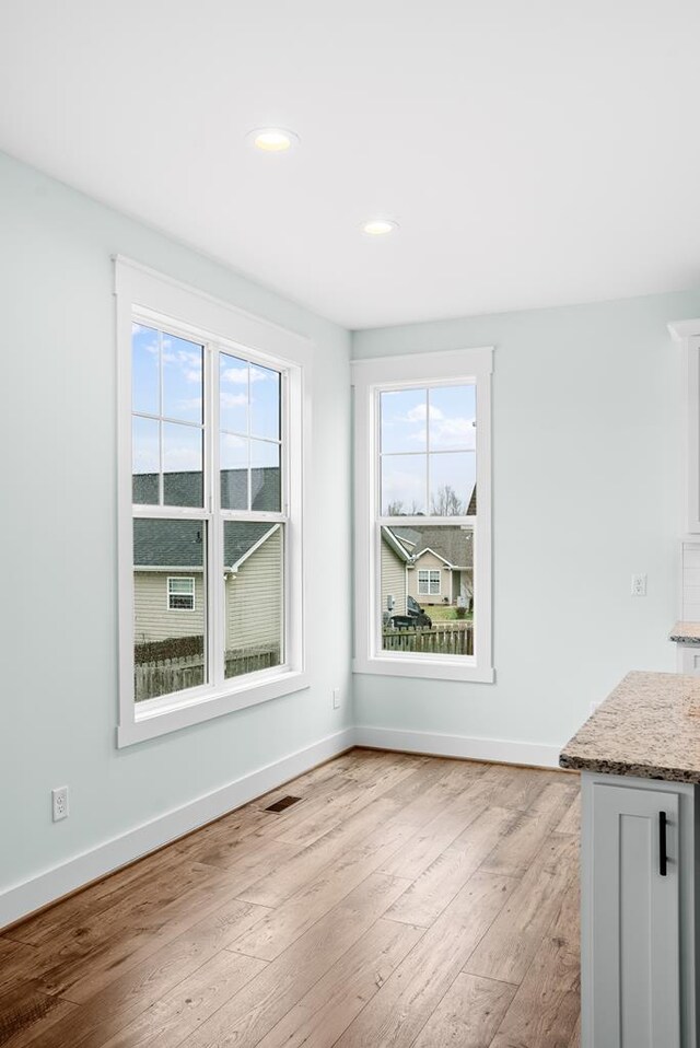 unfurnished dining area with light wood-style floors, recessed lighting, visible vents, and baseboards