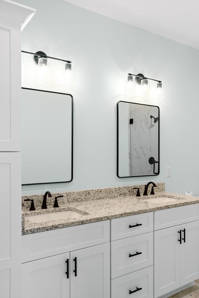 full bathroom with double vanity and a sink