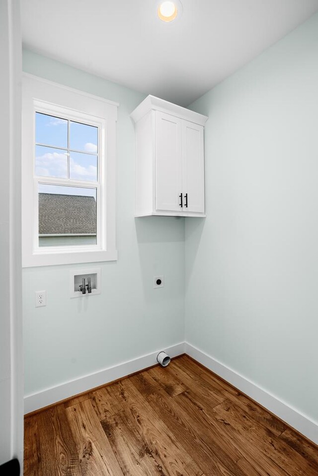 laundry room with washer hookup, cabinet space, hookup for an electric dryer, wood finished floors, and baseboards