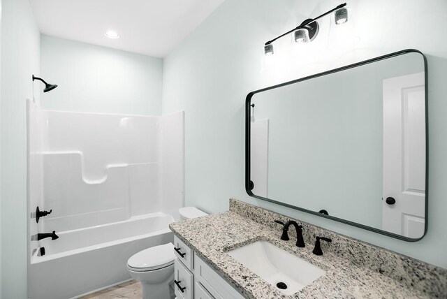 bathroom featuring bathing tub / shower combination, vanity, and toilet