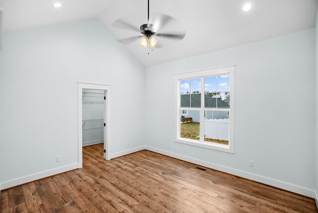 spare room featuring recessed lighting, a ceiling fan, vaulted ceiling, light wood-type flooring, and baseboards