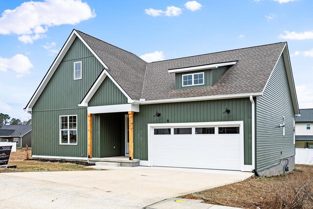 view of front of property with a garage, a shingled roof, and driveway