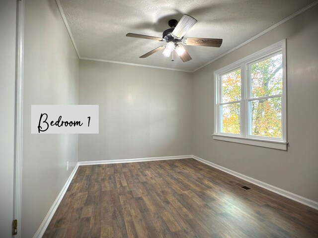 empty room featuring a textured ceiling, dark wood-style flooring, visible vents, baseboards, and ornamental molding