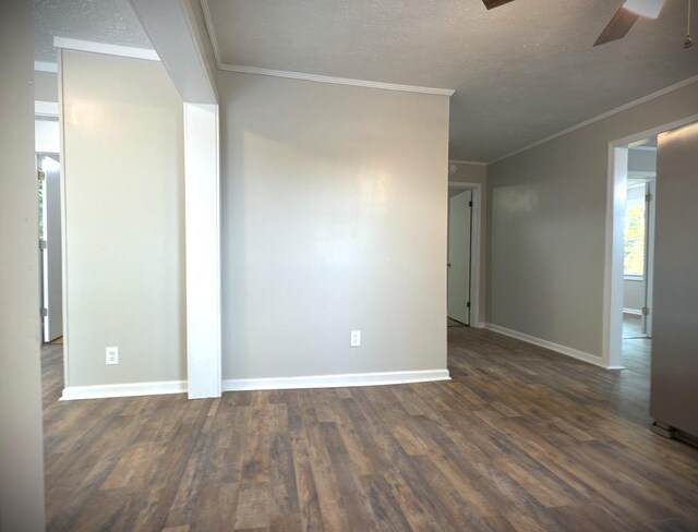 unfurnished room with crown molding, baseboards, dark wood finished floors, and a ceiling fan