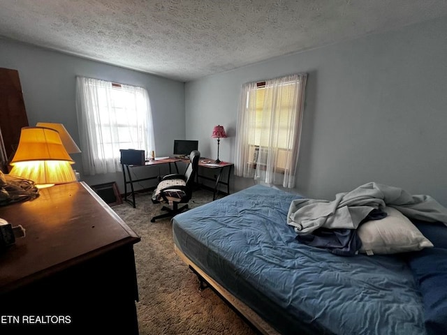 bedroom with a textured ceiling and carpet floors