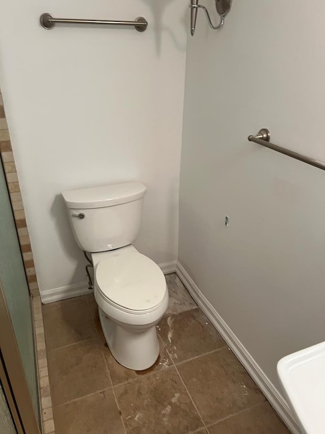 bathroom featuring toilet and baseboards