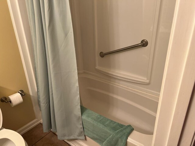 full bathroom featuring toilet, a shower with curtain, and tile patterned floors