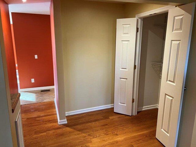 hallway featuring baseboards and wood finished floors