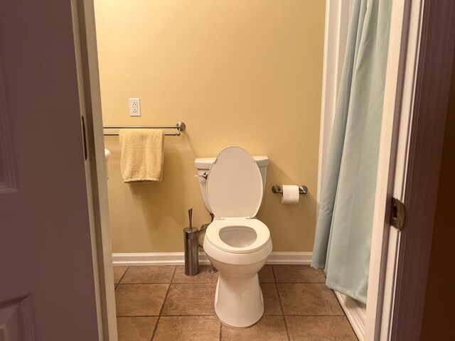 bathroom with baseboards, toilet, and tile patterned floors