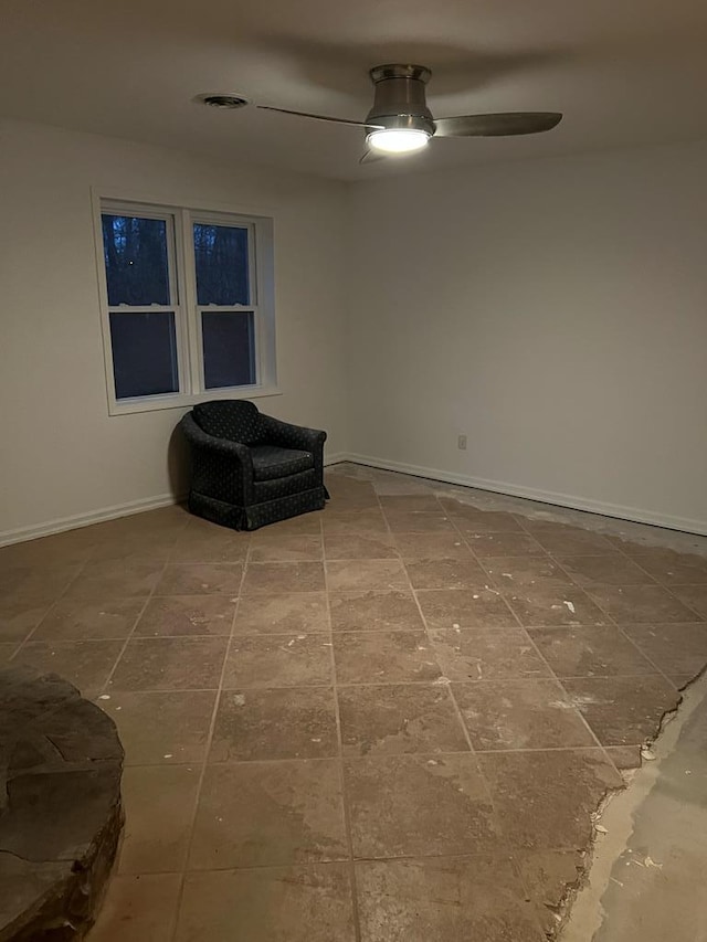 unfurnished room featuring a ceiling fan and baseboards