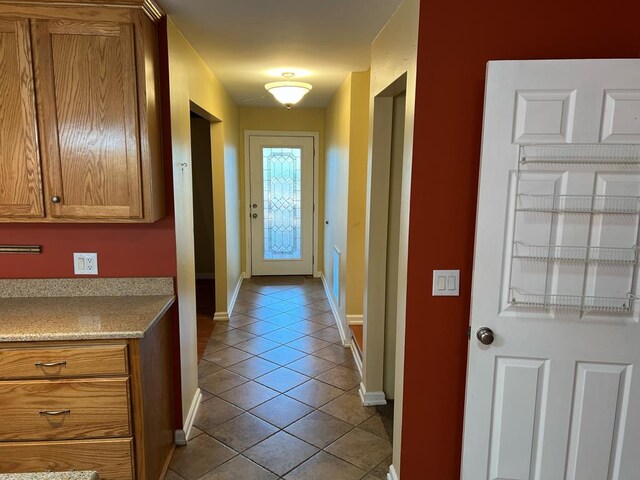 doorway to outside featuring baseboards and light tile patterned floors