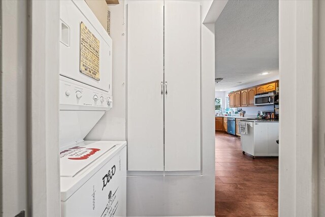 washroom with laundry area, dark wood-type flooring, and stacked washer / dryer