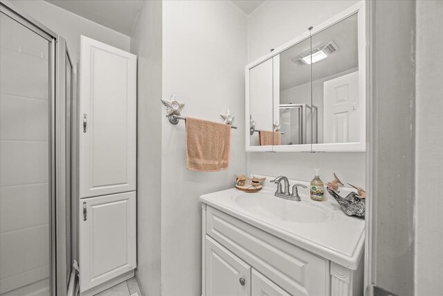 full bathroom featuring visible vents, vanity, and a shower stall