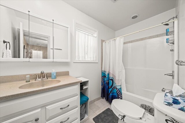 bathroom featuring toilet, shower / tub combo, vanity, and tile patterned floors