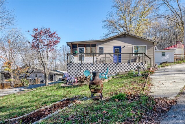 view of front facade featuring a front lawn and a sunroom