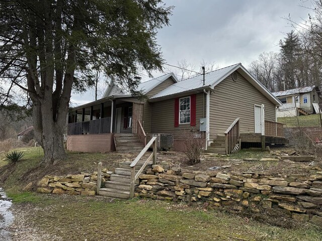 view of front of property featuring stairs, metal roof, and central AC unit