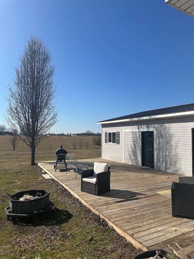 deck featuring an outdoor fire pit and a rural view