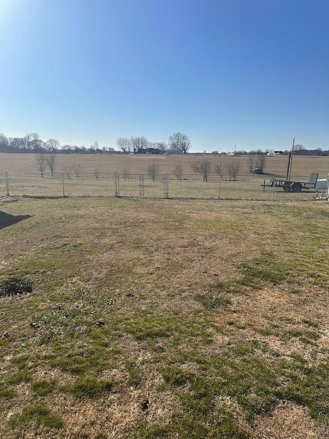 view of yard with fence and a rural view