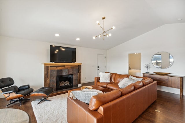 living area with baseboards, lofted ceiling, a fireplace, dark wood-style flooring, and a notable chandelier