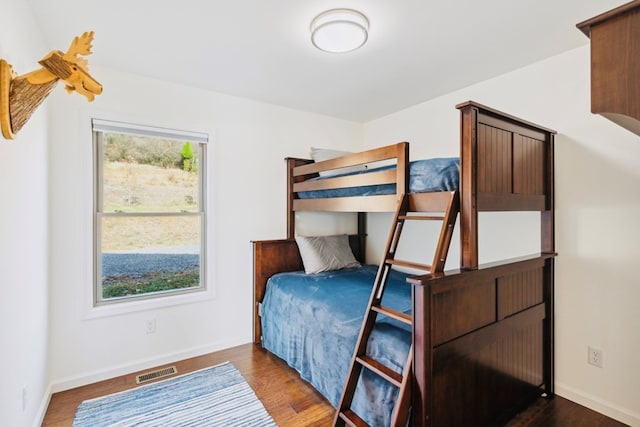 bedroom with visible vents, dark wood-type flooring, and baseboards