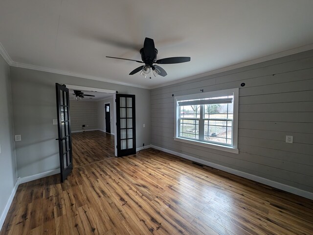 spare room featuring ornamental molding, wood finished floors, and baseboards