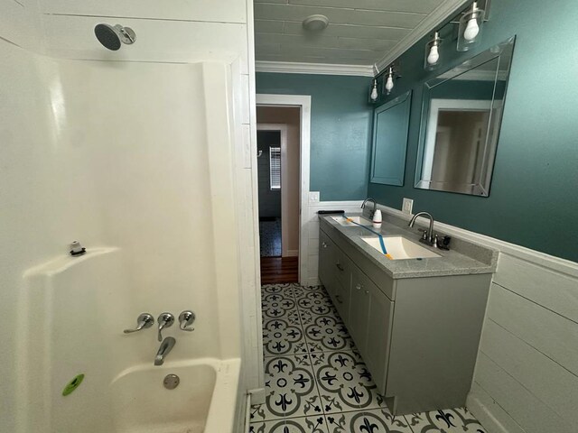 bathroom featuring a wainscoted wall, ornamental molding, tile patterned flooring, vanity, and shower / bathing tub combination