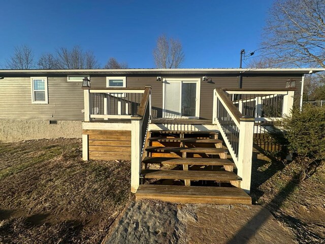 view of front of home with stairs, a deck, and crawl space