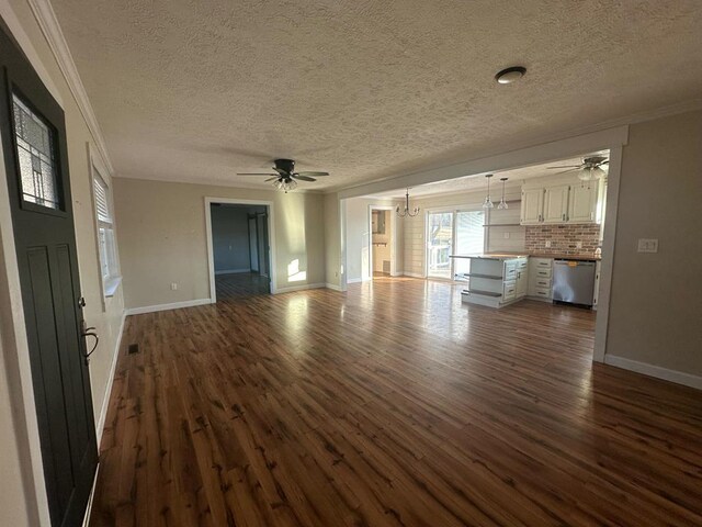 unfurnished living room with dark wood-style floors, ceiling fan with notable chandelier, and crown molding