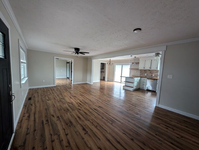 unfurnished living room with dark wood-style floors, ornamental molding, and baseboards