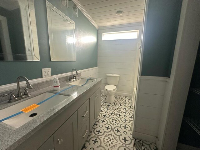 full bath featuring crown molding, double vanity, a sink, and tile patterned floors