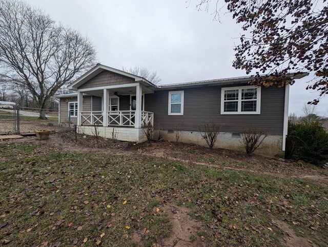 view of front facade featuring crawl space, covered porch, fence, and a front yard