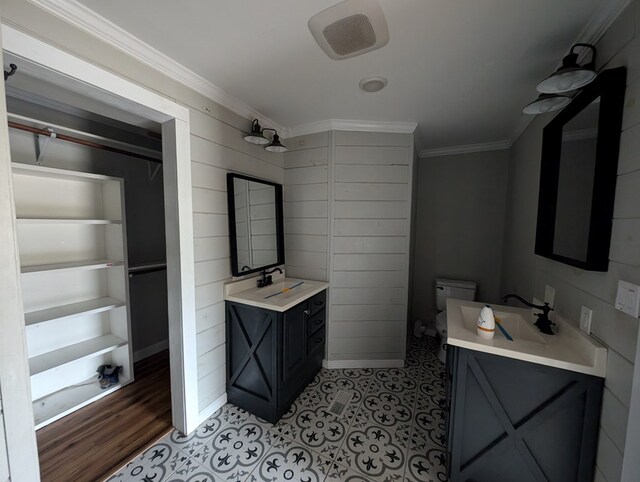 bathroom with toilet, ornamental molding, a closet, and vanity