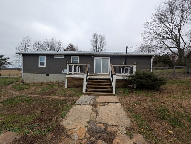 manufactured / mobile home with crawl space, fence, metal roof, a deck, and stairs