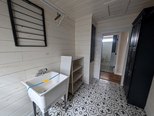 interior space featuring a sink, wood walls, and tile patterned floors