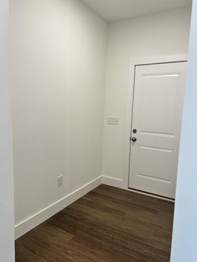 unfurnished room featuring dark wood-style floors and baseboards