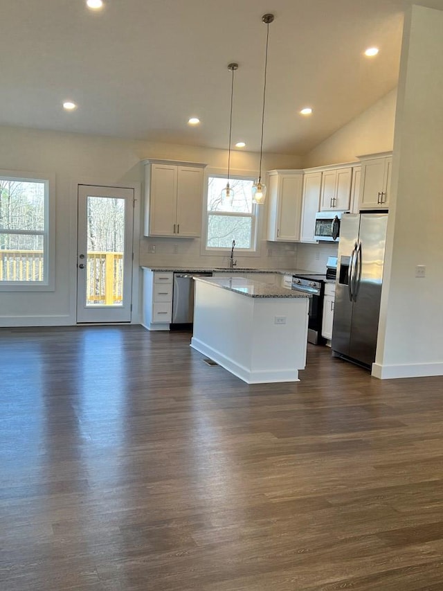 kitchen with stainless steel appliances, dark wood-type flooring, white cabinets, hanging light fixtures, and a center island