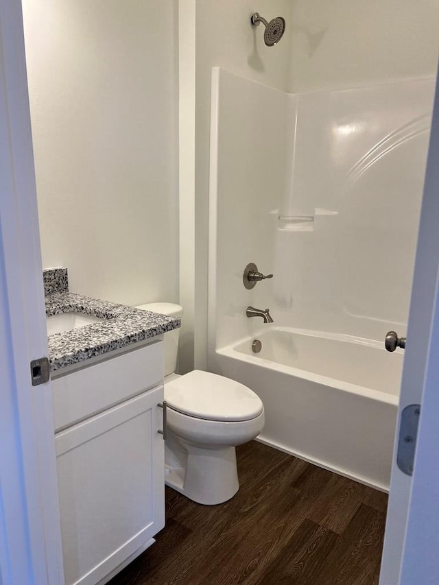 bathroom featuring tub / shower combination, vanity, toilet, and wood finished floors