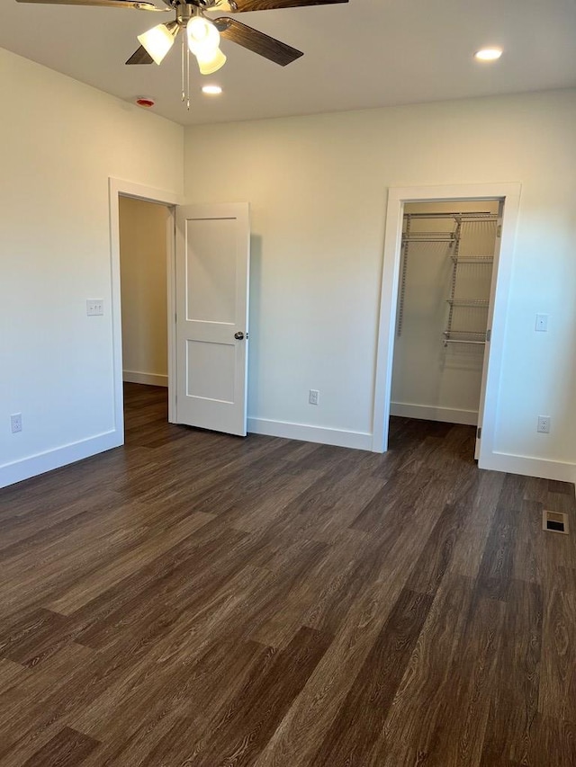 unfurnished bedroom featuring recessed lighting, visible vents, baseboards, a closet, and dark wood finished floors