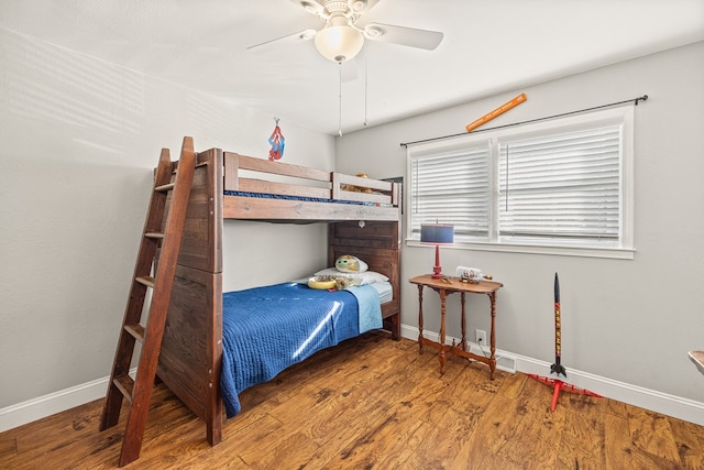 bedroom featuring ceiling fan, baseboards, and wood finished floors