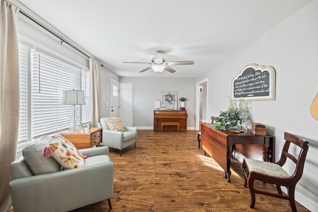 living area featuring wood finished floors, a ceiling fan, and baseboards