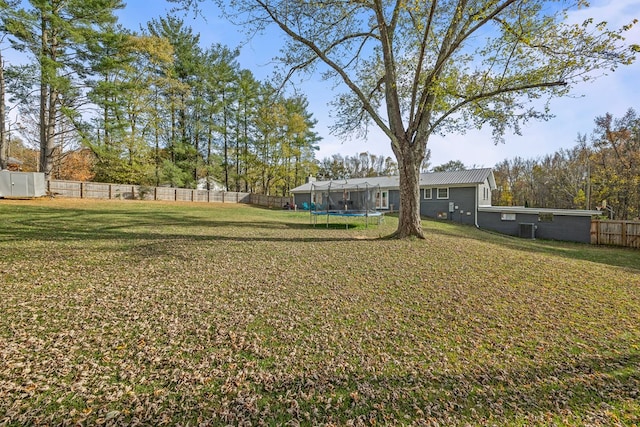 view of yard featuring a trampoline and a fenced backyard