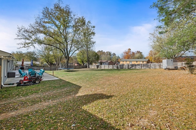 view of yard with a patio area, a fenced backyard, and a trampoline