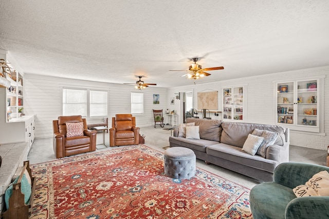 living room featuring light colored carpet, plenty of natural light, and a textured ceiling