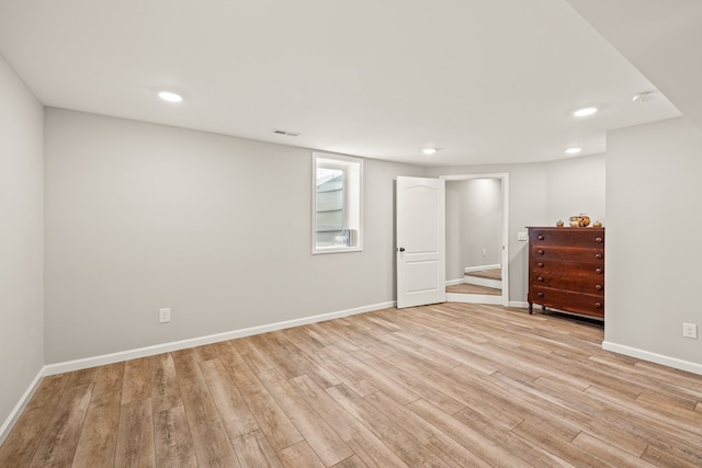 below grade area featuring light wood-type flooring, visible vents, baseboards, and recessed lighting